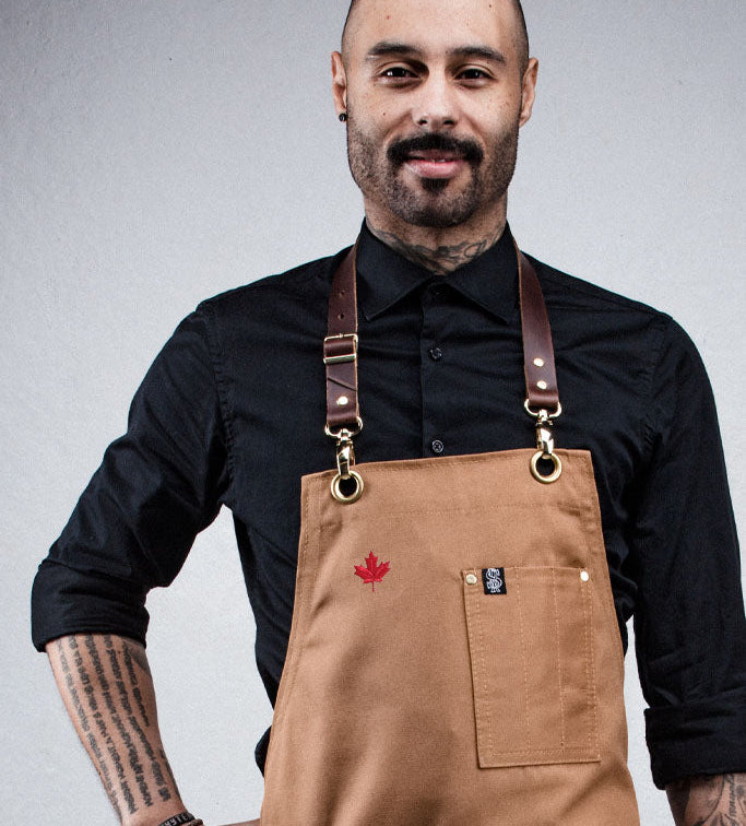 Man wearing a brown apron with a red maple leaf design on a gray background